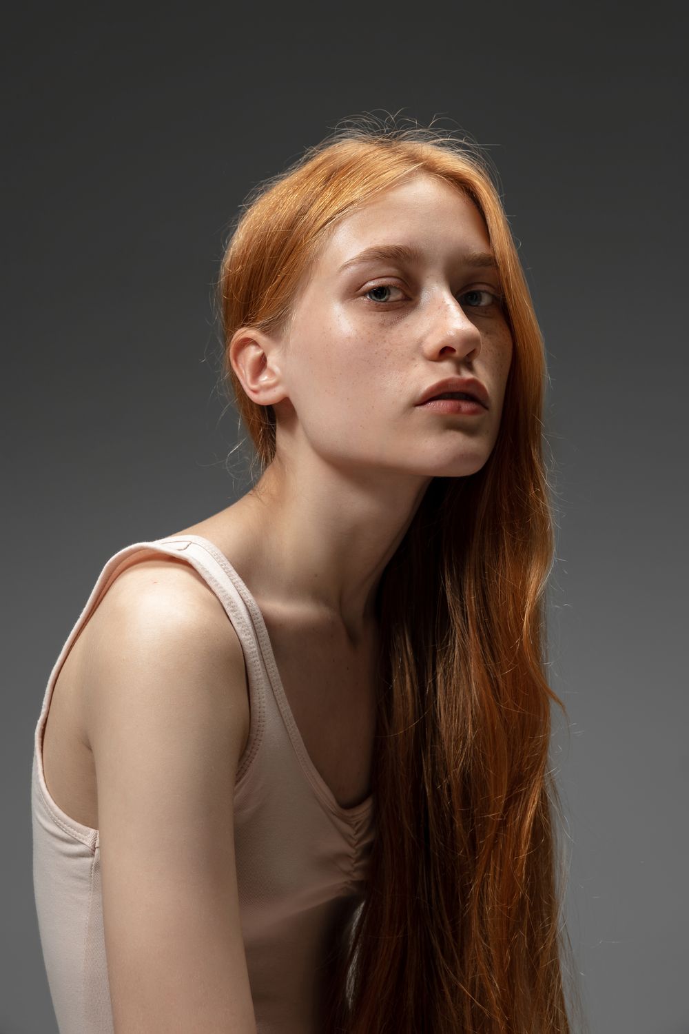 Young woman with long red hair and freckled skin.